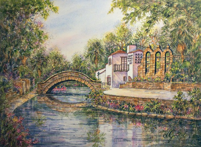 A stone bridge arches over the San Antonio River, where trees and riverside buildings reflect in the water.